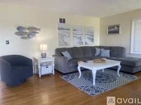 Onset house for rent - A living room with a grey couch, a white end table, and a blue chair.