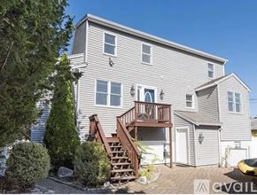 Onset house for rent - A house with a grey exterior and a wooden deck.