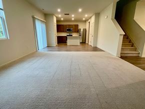 Louisville house for rent - A spacious living room with a carpeted floor and a staircase on the right side.