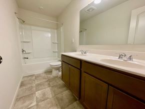 Louisville house for rent - A bathroom with a toilet, sink, and mirror.