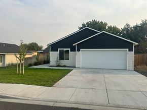Benton City house for rent - A two-car garage with a white door is attached to a house.