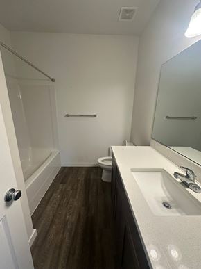 Benton City house for rent - A bathroom with a toilet, sink, and mirror.
