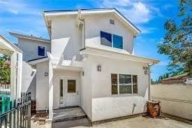 Los Angeles house for rent - A white two-story house with a blue window on the second floor.