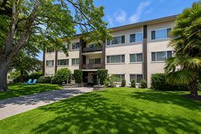 Vancouver apartment for rent - A building with a green lawn in front of it.