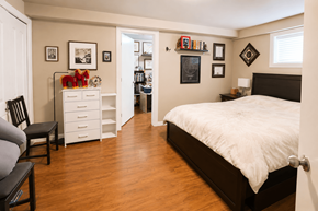 Vancouver apartment for rent - A bedroom with a white bed and a white dresser with a red object on top.