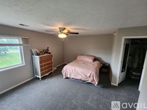 Caledonia condo for rent - A bedroom with a bed, dresser, and window.