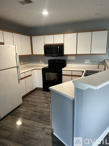 Caledonia condo for rent - A kitchen with white cabinets and a white refrigerator.