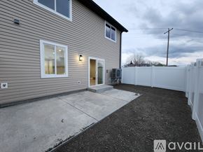 Elko apartment for rent - A house with a grey siding and a white fence in the backyard.
