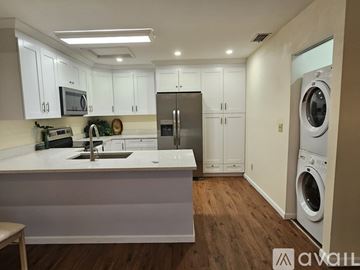 North Fort Myers house for rent - A modern kitchen with white cabinets and a wooden floor.