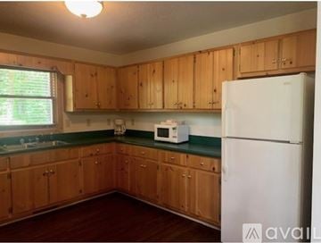 Dillard house for rent - A kitchen with wooden cabinets and a white fridge.