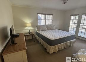 Dillard house for rent - A bedroom with a large bed and a television on a wooden dresser.