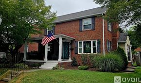 Frederick house for rent - A red brick house with a green door and an American flag on the porch.