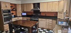 Frederick house for rent - A kitchen with wooden cabinets and a black and white checkered floor.