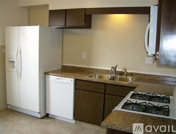 Elgin apartment for rent - A kitchen with a white fridge, dishwasher and stove top.