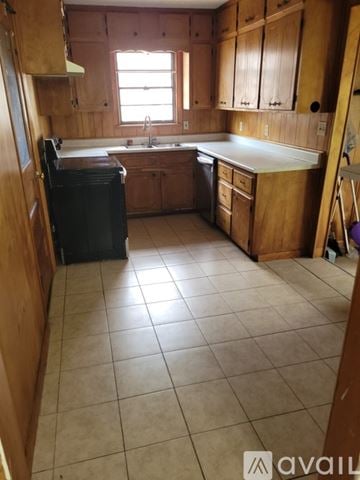Pasadena house for rent - A kitchen with wooden cabinets and a black dishwasher.