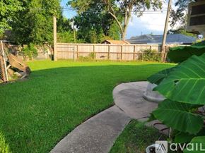 Pasadena house for rent - A backyard with a green lawn and a concrete walkway.