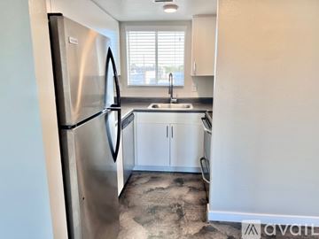 Phoenix apartment for rent - A kitchen with a stainless steel refrigerator and white cabinets.