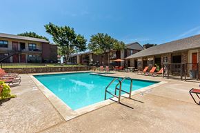 Irving apartment for rent - A swimming pool surrounded by a fence and chairs.