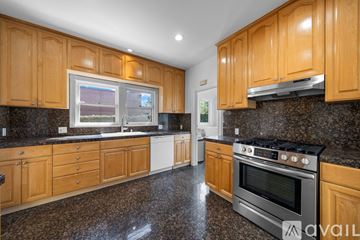 Los Angeles house for rent - A kitchen with wooden cabinets and granite countertops.