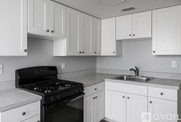 Tampa apartment for rent - A kitchen with white cabinets and a black stove top.