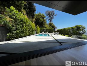 Los Angeles house for rent - A pool surrounded by trees and a building.