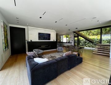 Los Angeles house for rent - A modern living room with a large couch and a television.