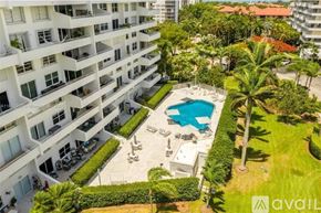Key Biscayne condo for rent - A large white building with a pool in the middle of a grassy area.
