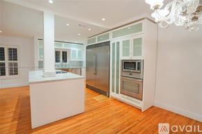 Key Biscayne house for rent - A kitchen with a white island and stainless steel appliances.