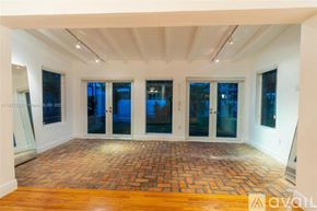 Key Biscayne house for rent - A spacious room with a brick floor and large windows.