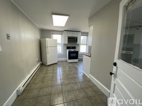 Duboistown apartment for rent - A room with a carpeted floor, two windows, and a door leading to another room.