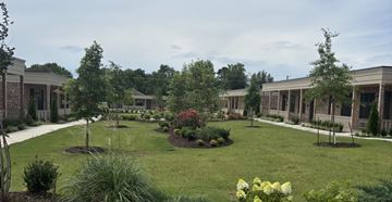Barling apartment for rent - A garden in front of a building with a white fence.