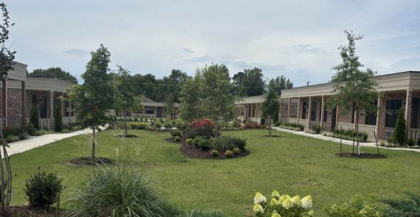 Barling apartment for rent - A garden in front of a building with a white fence.