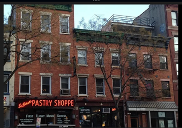 New York apartment for rent - A red brick building with a pastry shop on the ground floor.