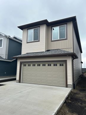 Edmonton apartment for rent - A two-story house with a garage door.