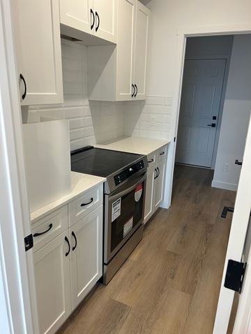Edmonton apartment for rent - A kitchen with white cabinets and a black stove top oven.
