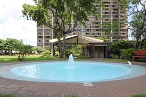 Honolulu apartment for rent - A fountain in the middle of a pool surrounded by a brick border.