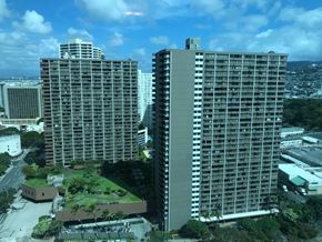 Honolulu apartment for rent - Two large buildings are seen from above with a green area in between.