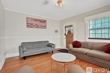 Jacksonville house for rent - A living room with a grey couch, a white table, and a painting on the wall.