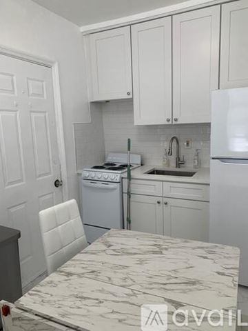 Miami Beach apartment for rent - A kitchen with white cabinets and appliances.
