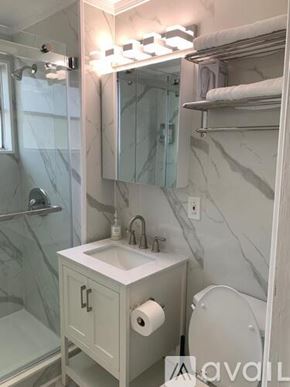 Miami Beach apartment for rent - A bathroom with a marble wall and a white sink.