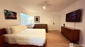 Miami Beach apartment for rent - A bedroom with a large bed and a flat screen TV mounted on the wall.