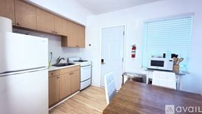 Miami Beach apartment for rent - A living room with a brown couch, a wooden table, and a white chair.