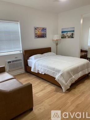 Miami Beach apartment for rent - A bedroom with a large bed and a brown chair.