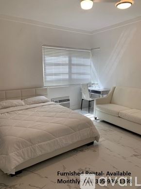 Miami Beach apartment for rent - A bedroom with a large bed and a couch is available for rent.