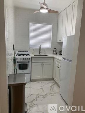 Miami Beach apartment for rent - A kitchen with a white stove, sink, and refrigerator.