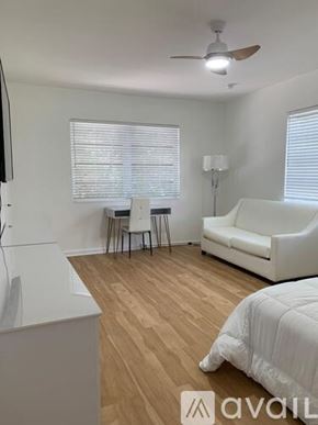 Miami Beach apartment for rent - A bedroom with a bed, a couch, a chair, and a ceiling fan.