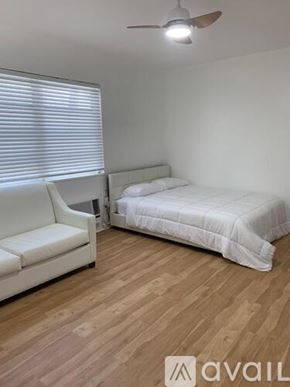 Miami Beach apartment for rent - A bedroom with a bed, a chair, and a ceiling fan.