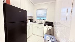 Miami Beach apartment for rent - A white bedroom with a large bed and a changing table.