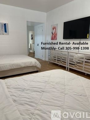 Miami Beach apartment for rent - A bedroom with a bed, a TV, and a sign that says "Furnished Rental- Available Monthly- Call 305-998-1398".