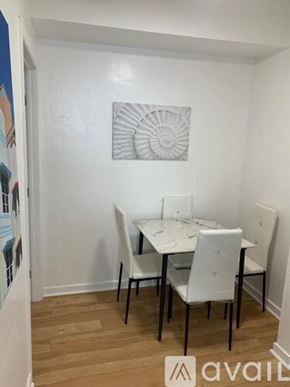 Miami Beach apartment for rent - A white dining table with four chairs in a room.